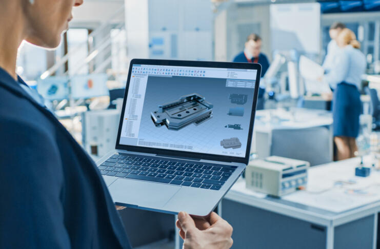 Stylish Female Industrial Robotics Engineer Uses Laptop Computer with CAD Software and to Manipulate and Program Robot Arm for Lifting, Moving Objects Technology Research Facility for Machine Learning