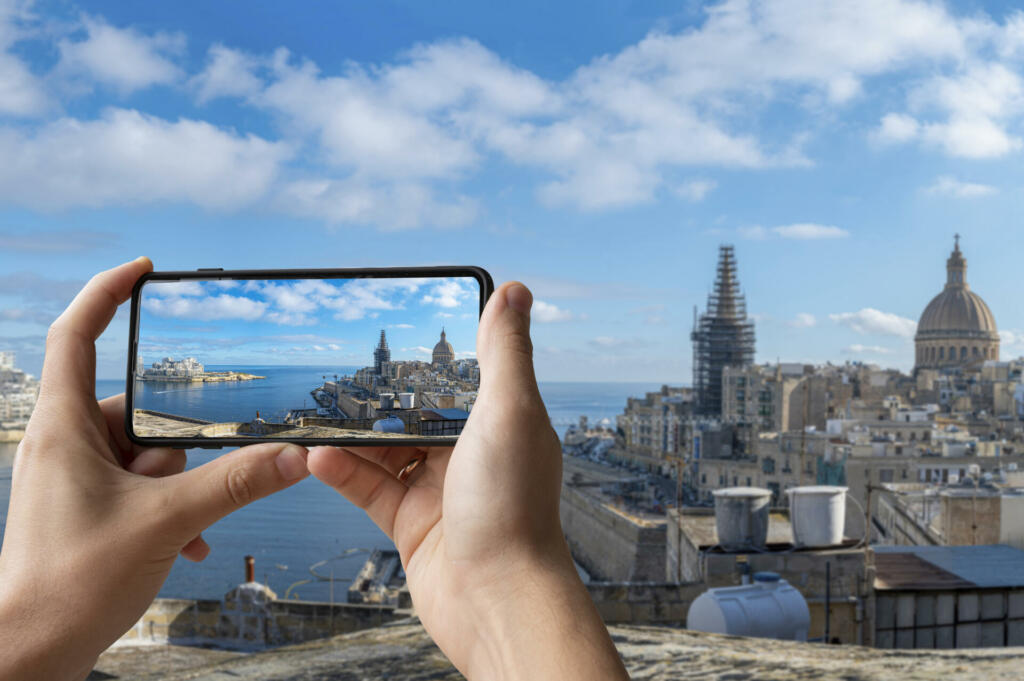 Tourist taking photo of Valletta harbor with Valletta old town and Sliema, Valletta, Malta.