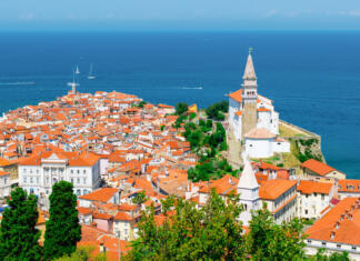 Univerza na Primorskem bo Koper spremenila v svet Travel to Slovenia. Cityscape of Piran with historic buildings and church. Adriatic sea in the background. Panoramic picture.