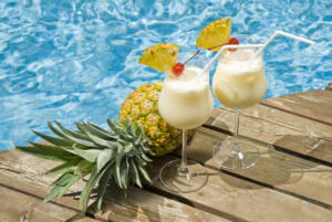 Two Glasses of Pina Colada Cocktail by a Swimming Pool
