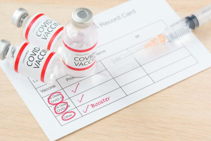 Vaccination record card showing booster dose of covid-19 vaccine. The thrid vaccination for immunity against delta variant.