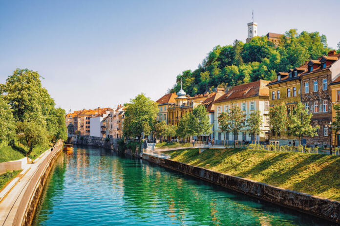 Waterfront of Ljubljanica River and Old castle on Castle hill in the historical center of Ljubljana, Slovenia