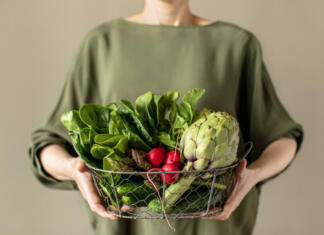 Če si vegan, še ne pomeni, da se prehranjuješ zdravo! Woman holding a basket full of fresh veggie produce, healthy food, or healthy sustainable living concept