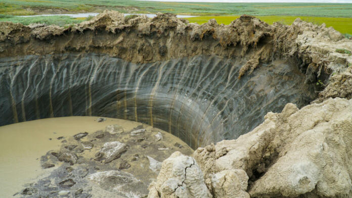 YAMAL PENINSULA, RUSSIA - JUNE 18, 2015: Helicopter expedition to the giant funnel of unknown origin. Crater view.