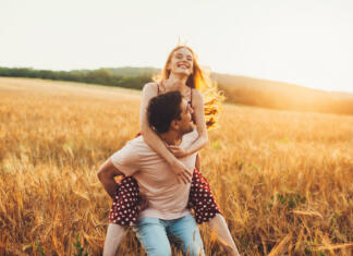 Študija dokazuje, da se moški rajši crkljajo Young couple having fun in the wheat field. Piggy back rides. Family weekend.