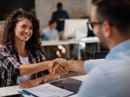 Young woman signing contracts and handshake with a manager