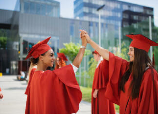 Akademija Strojnik.si – vsebine, ki so blizu mladim A group of cheerful university students celebrating outdoors, graduation concept.