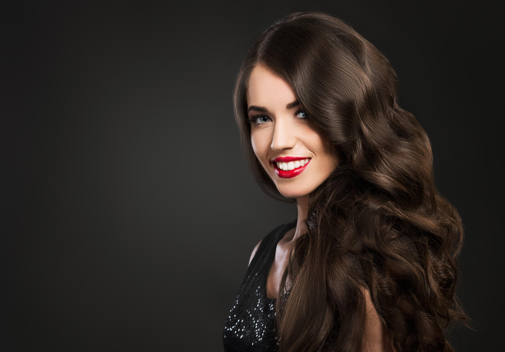 Beautiful woman smiling, glamour portrait on dark background