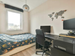 Compact bedroom with single bed and work area at home