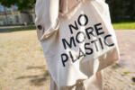 Cropped head close up of female walking in park with ecology friendly bag for protecting environment