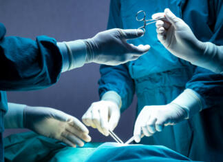 Bo moral slovenski kirurg Dolenc plačati 2,3 milijona odškodnine? doctor and nurse medical team are performing surgical operation at emergency room in hospital. assistant hands out scissor and instruments to surgeons during operation.