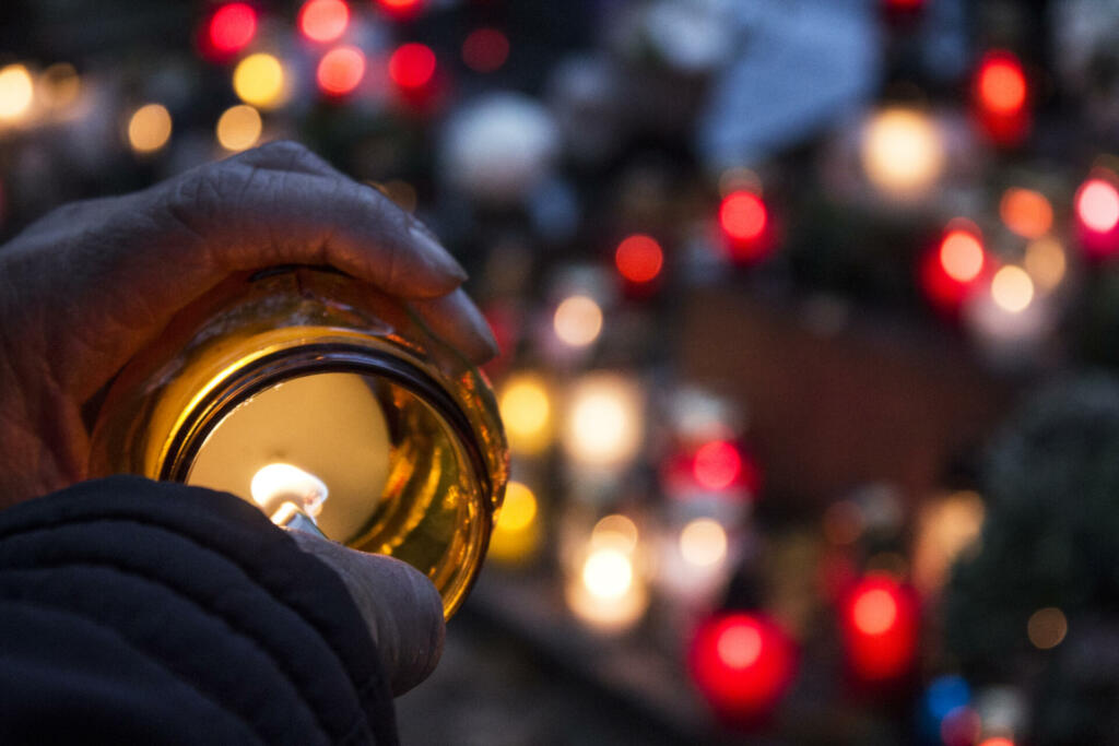 Female lights candle to put on a grave