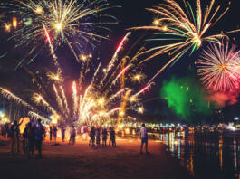 Fireworks with silhouettes of people in a holiday events.New Year fireworks on the beach. Travelers and people celebrate New year day at Kamala Beach Phuket, Thailand.