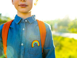 girl in denim t-shirt with rainbow symbol wear backpack in summer park outdoor.