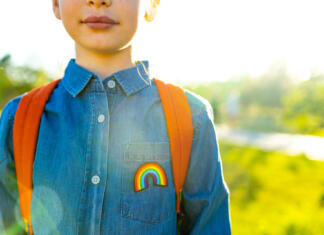Vlada sprejela popravljen družinski zakonik girl in denim t-shirt with rainbow symbol wear backpack in summer park outdoor.