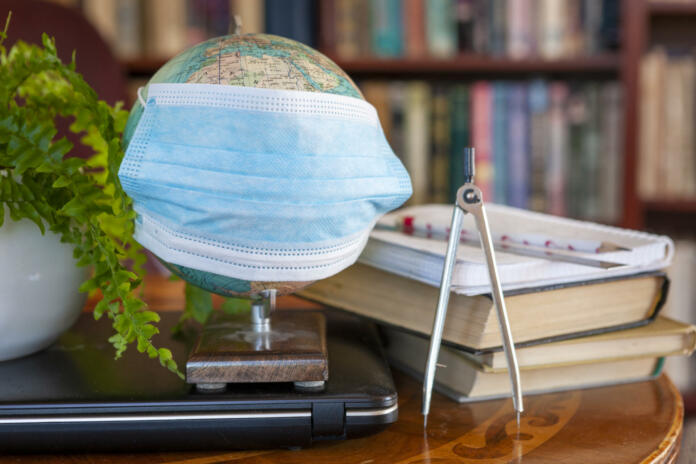 Globe wearing a mask, Informational digital detox. Home education during the coronavirus pandemic, future travels planning. Books instead of news, virtual games.