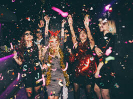 Group of friends having fun for new year's eve in a club. Drinking and dancing together
