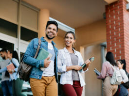 Happy university student and his female friend walking after the lecture at campus.