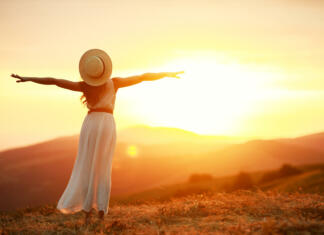 Samopodoba in javno nastopanje s Sašo Einsiedler Happy woman standing with her back on the sunset in nature in summer with open hands