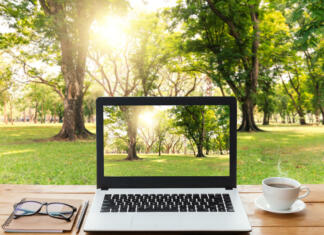 Raziskava: Nakup rabljenega prenosnika v številkah – okolje, prihranek, zanesljivost in življenjska doba laptop computer and coffee on wood workspace and park background