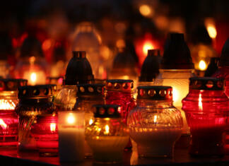 Prvi november in 9,45 milijonov nagrobnih sveč lot of bright, colorful candles standing on graves in the cemetery at night