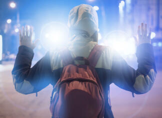 Se bliža izboljšanje mladostniškega kazenskopravnega sistema? male suspect arrested in the night city, with police flashers behind him