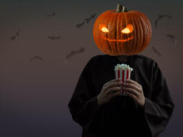Man with a pumpkin head and with popcorn for Halloween. tinting. selective focus