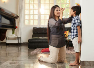 Nova študija razkriva genetske povezave z višino Mother checking her son's height at home