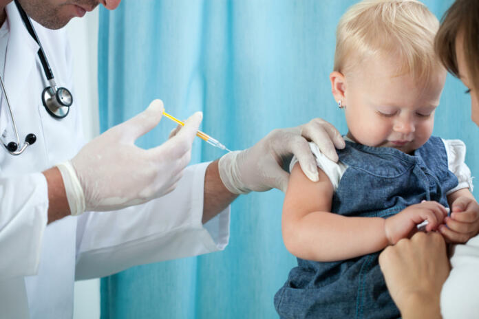 Pediatrician makes vaccination to small girl