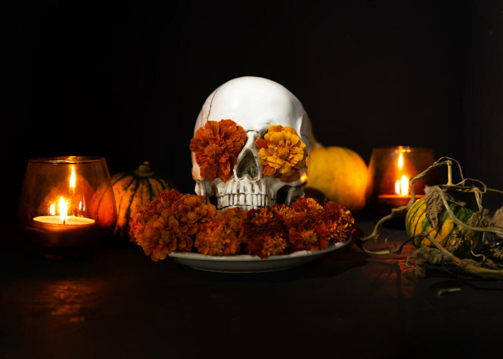 Skull, Burning candles and orange marigold flowers on black background. Concept of Dia de los muertos day or day of the dead. Dark halloween banner.