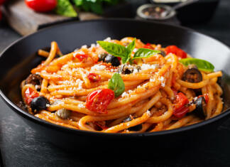 Testenine na sto in en način Spaghetti alla puttanesca - italian pasta dish with tomatoes, black olives, capers, anchovies and basi