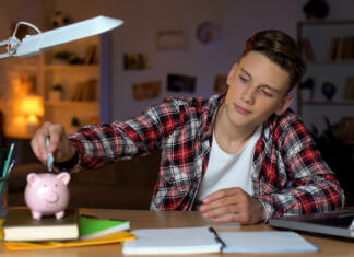 Zvišala se je vrednost študentskih bonov Teenager holding euro banknote putting it to piggyback, financial education