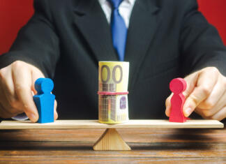 Si »levi« ali »desni«? Ugotovi, kje na politični lestvici ležiš! The businessman puts the figure of a man and a woman on the scales with money. Concept of gender pay gap. Income inequality. Oppression of women. Gender discrimination. Underestimation of female labor