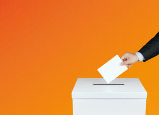 Študenti, danes so volitve! The hand of man putting his vote in the ballot box.