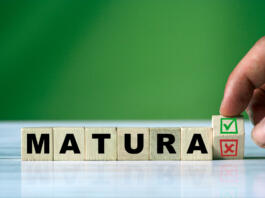 The hand turns the wooden cube and changes the polish word MATURA (english = secondary school certificate) with green positive tick check box and red reject X check box.