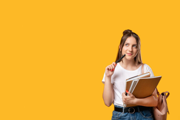 Think idea. Student lifestyle. Puzzled woman with notebooks and backpack isolated on orange copy space. Doubt face. New project. Advertising background