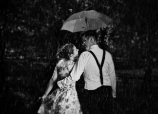 Top zgodovinski ljubezenski romani Young romantic couple in love flirting in rain, man holding umbrella. Dating, romance, black and white