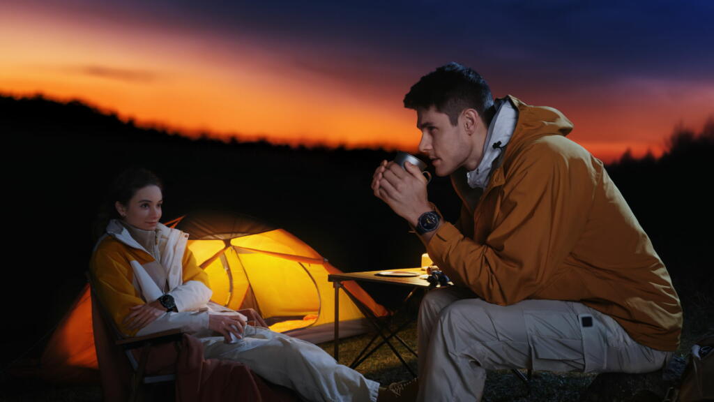 Moški in ženska sedita poleg šotora