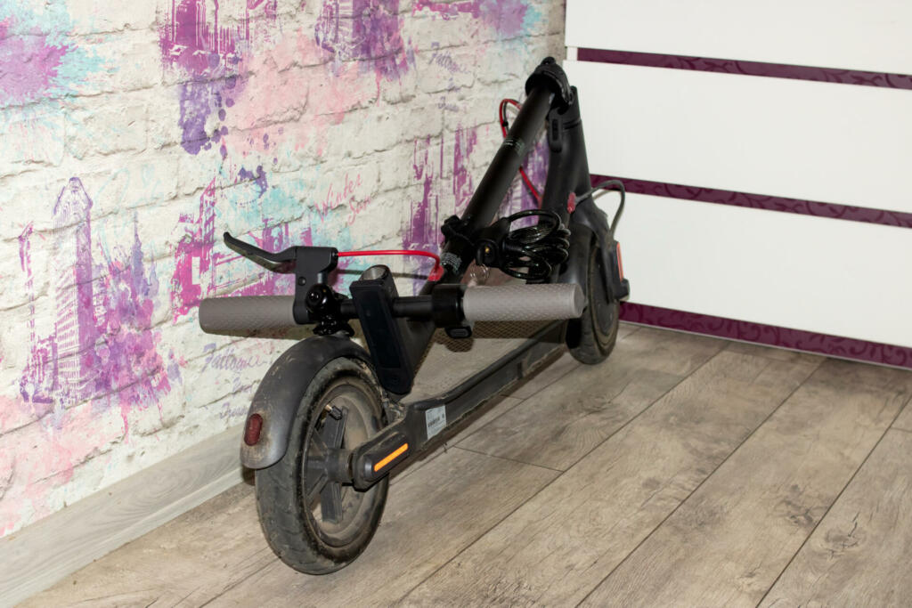 Belarus, Novopolotsk - 18 august, 2021: Folded electric scooter against the wall close up