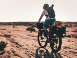 Oseba s kolesom potuje po puščavi