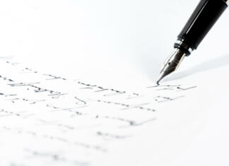 Prihodnje leto bo v znamenju Karla Destovnika Kajuha! Black fountain pen is writing a letter or a manuscript on a white paper, copy space, close-up shot with selected focus and narrow depth of field