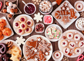 Tretji dobri mož, ki prinaša zvrhan koš daril Christmas table scene of assorted sweets and cookies. Top view over a rustic wood background. Holiday baking concept.