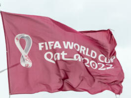 Doha, Qatar - January 15th 2022: Maroon Fifa World Cup Qatar 2022 flag flying in the sky above Doha