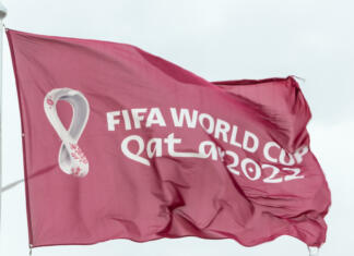 Svetovno prvenstvo 2022 ali zakaj bi ga morali bojkotirati? Doha, Qatar - January 15th 2022: Maroon Fifa World Cup Qatar 2022 flag flying in the sky above Doha