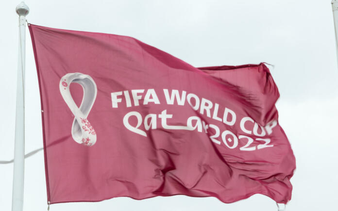 Doha, Qatar - January 15th 2022: Maroon Fifa World Cup Qatar 2022 flag flying in the sky above Doha