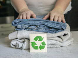 Garment recycling concept. A stack of clothes is on the recycling table. Collection of clothes for recycling.