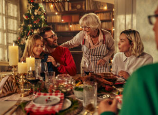 3 praznični okusi vročih čokolad Happy multi-generation family talking while having New Year's meal at dining table.