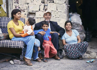 Reševanje romske problematike: »Cilj je zagotoviti romski populaciji dostojne pogoje« KAGITHANE GULTEPE, ISTANBUL, TURKEY - AUG. 2008: Group portrait of a poor Turkish (roman) gypsy family sitting on the street in front of their ruin shanty house. Editorial use only.