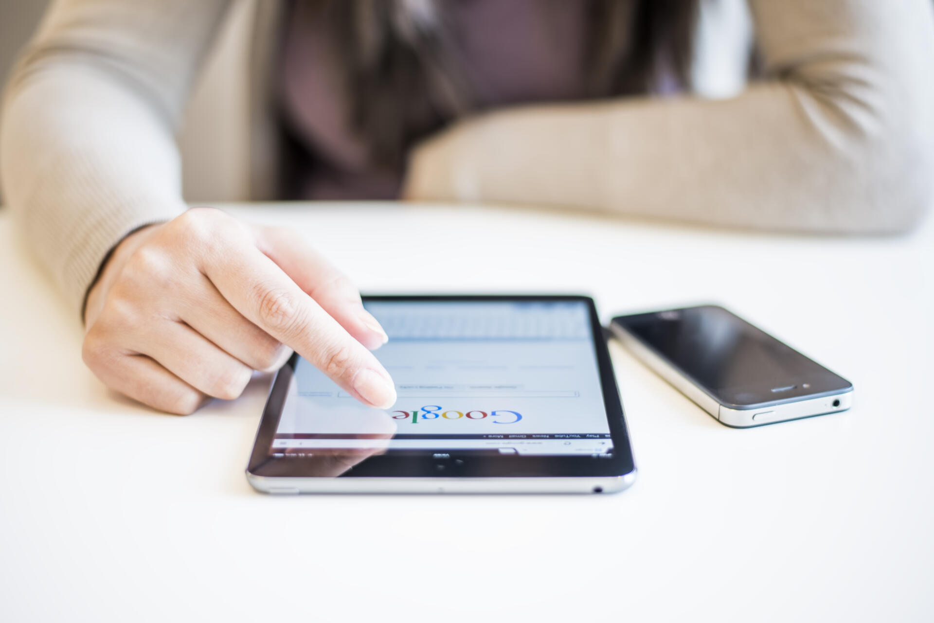 Novi Sad, Serbia - October 6, 2014: Woman's hands Googling on electronic device.Woman hands holding and touching on Apple iPad mini with Google search web page on a screen.