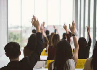 Nič o mladih brez mladih: Nacionalni program za mladino Raised up hands and arms of large group in seminar class room at Conference